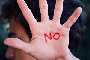 Boys hand with a red "NO" painted on his palm