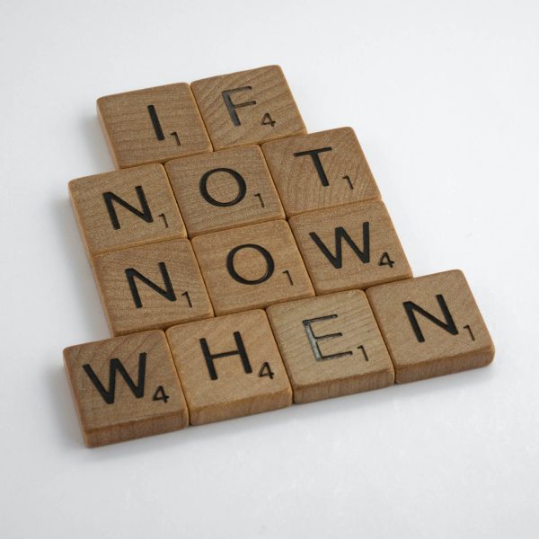 Wooden scrabble pieces spelling out "If not now, when." Eliminate procrastination with a Mind Beliefs course!