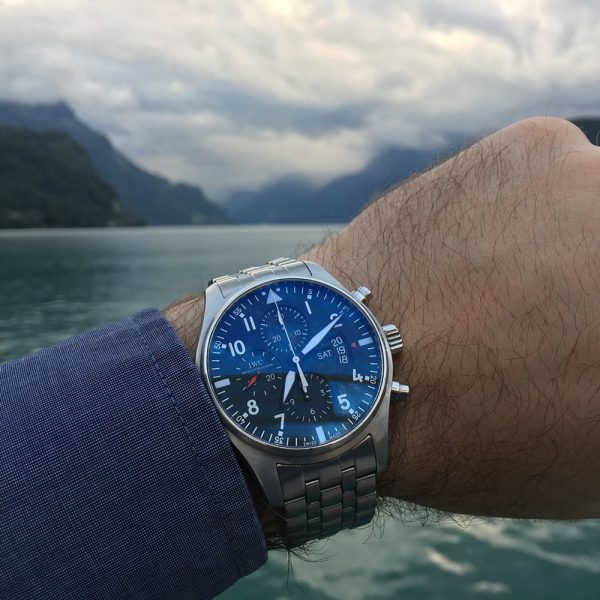 Man's watch is framed in front of a mountainscape and clouds. Master your discipline muscle with Mind Truths courses!