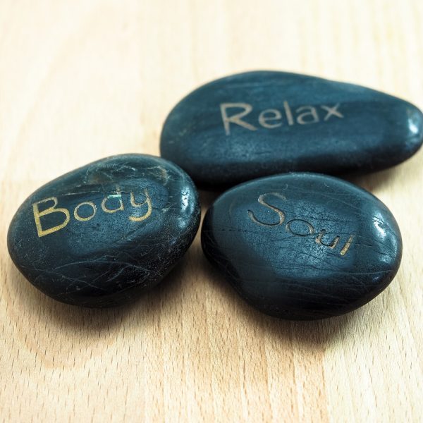 Stones with words of relax, body, and soul. Become aware of present thought and physical body with our Meditation Courses!